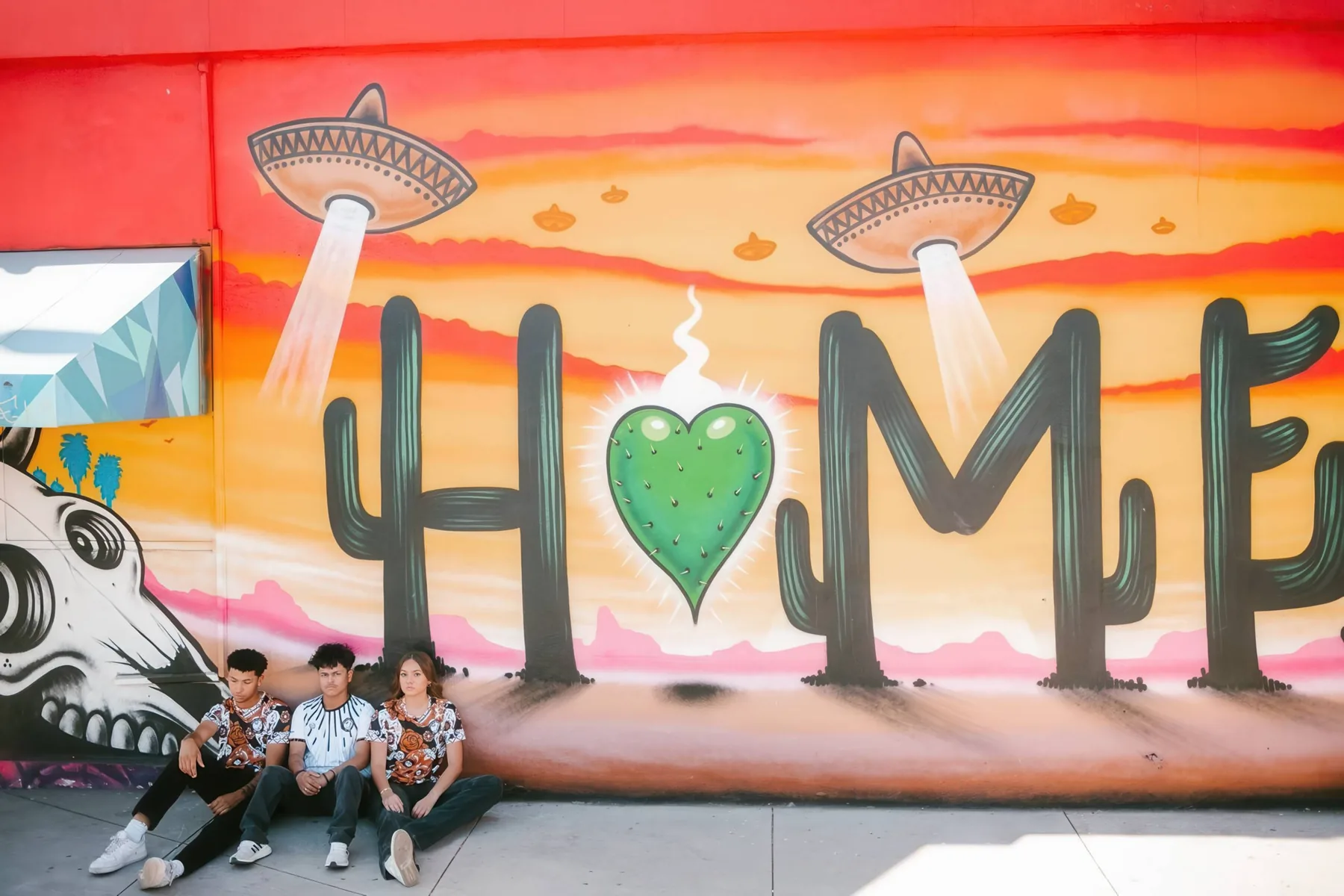 State 48 players seated in front of a colorful Phoenix mural